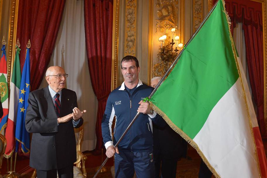Il presidente della Repubblica Giorgio Napolitano consegna la bandiera a Zoeggeler durante la cerimonia di consegna della bandiera agli atleti italiani in partenza per i Giochi Olimpici Invernali di Soci 2014 (Ansa)